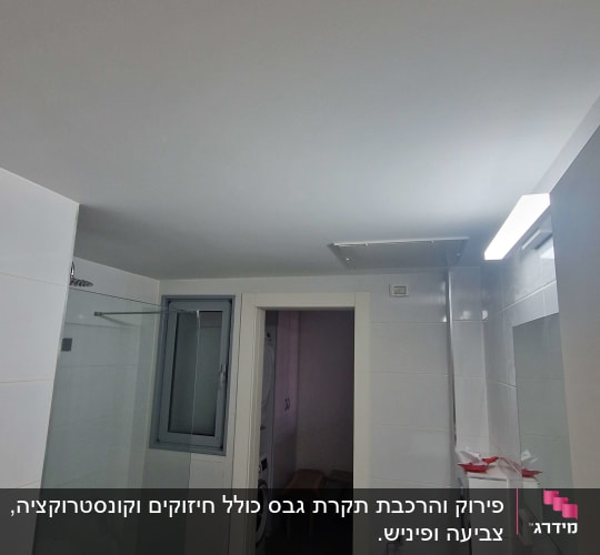 חדר אמבטיה עם מקלחת, כיור ומראה